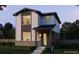 Modern two-story home featuring a welcoming porch, large windows, and contemporary design elements at 21144 E 63Rd Dr, Aurora, CO 80019