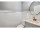 Stylish half bathroom with wainscotting, modern fixtures, and round mirror at 8625 E 125Th Ct, Thornton, CO 80602