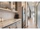 Stylish kitchen with gray cabinets, granite countertops, wine cooler, and subway tile backsplash at 8625 E 125Th Ct, Thornton, CO 80602