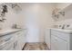 Bright laundry room with white cabinets, quartz countertops, and modern washer and dryer at 8625 E 125Th Ct, Thornton, CO 80602