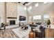 Bright living room showcasing a stone fireplace, large windows, and a comfortable seating arrangement at 8625 E 125Th Ct, Thornton, CO 80602