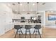 Modern kitchen features a center island with pendant lighting, light countertops, and stylish backsplash at 3381 N Denali St, Aurora, CO 80019