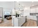 View of modern kitchen with center island, stainless appliances and open to living area at 3381 N Denali St, Aurora, CO 80019