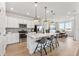 Bright kitchen with stainless appliances, white cabinetry, an island with seating, and adjacent dining area at 3381 N Denali St, Aurora, CO 80019