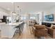 Open-concept living space with an island, modern lighting, and large windows at 3381 N Denali St, Aurora, CO 80019