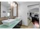Bright bathroom featuring double sinks, modern fixtures, a mosaic tile accent wall, and an open doorway at 10991 Expedition, Littleton, CO 80125