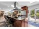 Open concept kitchen with stainless hood vent, stone countertops, large island with seating and an outdoor patio at 10991 Expedition, Littleton, CO 80125
