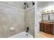 Tiled shower with a rainfall shower head, matte black fixtures, and decorative accent tiles at 10991 Expedition, Littleton, CO 80125