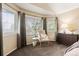 Bright bedroom with natural light, chair, and wooden dresser at 7307 Pine Forest Ln, Parker, CO 80134