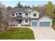 Charming two-story home with a lush lawn, blue garage doors, and inviting curb appeal at 7307 Pine Forest Ln, Parker, CO 80134