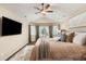 Bright main bedroom features a cozy bay window, ceiling fan and wall-mounted television at 7307 Pine Forest Ln, Parker, CO 80134