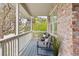 Relaxing covered porch with outdoor seating, a brick wall, and views of the surrounding trees at 7307 Pine Forest Ln, Parker, CO 80134