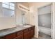 This bathroom features a dark countertop, dark cabinetry, and a mirror with modern lighting at 6742 S Winnipeg Cir # 105, Aurora, CO 80016