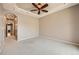 Neutral bedroom features carpeted floors, tray ceiling with fan, and hallway access to the rest of the home at 6742 S Winnipeg Cir # 105, Aurora, CO 80016