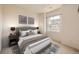 This bedroom features neutral walls, carpet, a padded headboard, and a window for natural light at 6742 S Winnipeg Cir # 105, Aurora, CO 80016