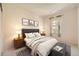 This bedroom features neutral walls, carpet, a padded headboard, and a window for natural light at 6742 S Winnipeg Cir # 105, Aurora, CO 80016