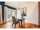 Modern dining room with hardwood floors, a chandelier, and a glass table with seating for two at 6742 S Winnipeg Cir # 105, Aurora, CO 80016