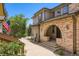 Charming multi-story exterior view with brick archway and mature landscaping on a sunny day at 6742 S Winnipeg Cir # 105, Aurora, CO 80016