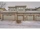 Residential garages, each distinguished by unique unit numbers, complete with snow-dusted driveways at 6742 S Winnipeg Cir # 105, Aurora, CO 80016