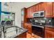 Cherry wood kitchen featuring granite counters, stainless steel appliances, and decorative pendant lights at 6742 S Winnipeg Cir # 105, Aurora, CO 80016