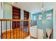 This landing features wooden floors, built-in shelves, and a decorative chandelier at 6742 S Winnipeg Cir # 105, Aurora, CO 80016