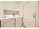 This laundry room features a washer, dryer, shelf, and doorway at 6742 S Winnipeg Cir # 105, Aurora, CO 80016