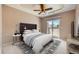 Bedroom with tray ceiling, ceiling fan, and balcony with sliding glass door and neighborhood views at 6742 S Winnipeg Cir # 105, Aurora, CO 80016