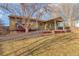 Large backyard with a spacious deck, covered patio, mature trees, and a well-maintained lawn at 6812 Blue Jay Dr, Parker, CO 80138