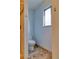 Powder room featuring toilet and window with slate tile floors at 6812 Blue Jay Dr, Parker, CO 80138