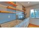 Stylish kitchen featuring a modern gas range, granite counters, and floating wood shelves at 6812 Blue Jay Dr, Parker, CO 80138