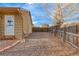 Side yard with a gravel surface, enclosed by a wooden fence, offering privacy and potential at 6812 Blue Jay Dr, Parker, CO 80138