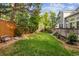 Well-manicured backyard with lush green grass, mature trees, and a cozy bench seating area at 15597 E Dorado Ave, Centennial, CO 80015