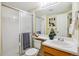 Well-lit bathroom featuring a shower, a large mirror, and a stylish vanity with modern fixtures at 15597 E Dorado Ave, Centennial, CO 80015