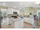 Open kitchen with an island, white cabinets, stainless steel appliances, and bright natural light at 15597 E Dorado Ave, Centennial, CO 80015