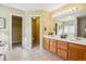 Large primary bathroom with dual sinks, wooden cabinets, and separate rooms for bath, toilet and closet at 15597 E Dorado Ave, Centennial, CO 80015