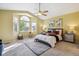 Serene main bedroom with large windows, a ceiling fan, and a comfortable bed with decorative pillows at 15597 E Dorado Ave, Centennial, CO 80015