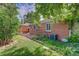 Brick home with a backyard, patio, garden bed, mature landscaping, and privacy fence at 1541 Poplar St, Denver, CO 80220