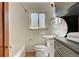 Bright bathroom has classic white tile, window and a modern pedestal sink at 1541 Poplar St, Denver, CO 80220