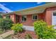 Inviting front porch with brick facade, manicured bushes, and a secure front door at 1541 Poplar St, Denver, CO 80220