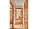 Hallway with hardwood floors and vintage wood trim detail leading to bright bedroom at 1541 Poplar St, Denver, CO 80220