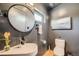 Contemporary bathroom with a round mirror, vessel sink, modern fixtures, and textured gray walls at 3850 Vallejo St, Denver, CO 80211