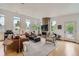 Bright living room with stone fireplace, hardwood floors and multiple windows showing outdoor views at 3850 Vallejo St, Denver, CO 80211