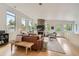 Sunlit living room featuring a brick fireplace, hardwood floors, and comfortable seating at 3850 Vallejo St, Denver, CO 80211
