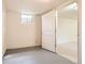 An empty basement room with a door and one window at 1860 W Crestline Dr, Littleton, CO 80120