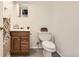 A simple half-bathroom with a sink, mirror, toilet, and painted floor at 1860 W Crestline Dr, Littleton, CO 80120