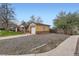 Exterior view of a home with a driveway, a detached garage, and a mix of gravel and grassy landscaping at 1860 W Crestline Dr, Littleton, CO 80120