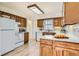 The kitchen has wood cabinets, white appliances, and a window above the sink, providing natural light at 1860 W Crestline Dr, Littleton, CO 80120