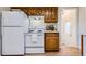 A clean kitchen featuring white appliances, wood cabinets and modern flooring at 1860 W Crestline Dr, Littleton, CO 80120