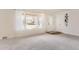 Bright, carpeted living room with large windows, a decorative shelf and a front door at 1860 W Crestline Dr, Littleton, CO 80120