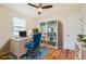 Bright home office features hardwood floors, white desk, and stylish blue chair at 1860 W Crestline Dr, Littleton, CO 80120
